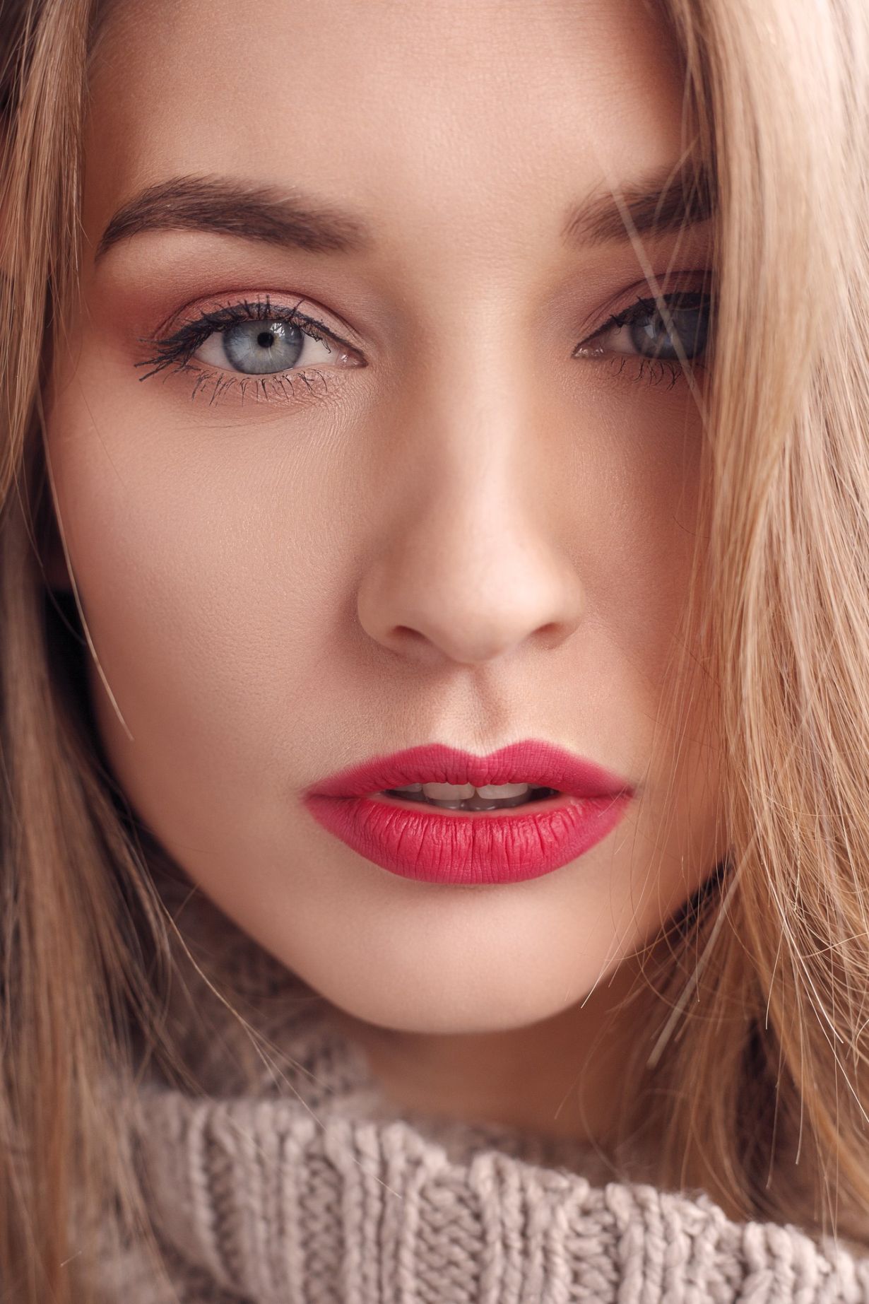 model in a pink jumper with red lipstick posing for the camera