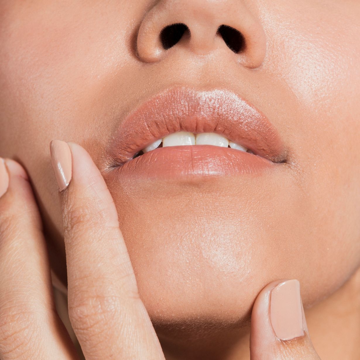 lower haf of a womans face showing her fingers touching her lips